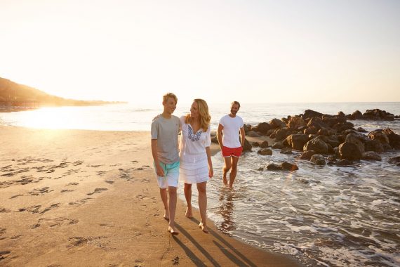 Familie beim Strandspaziergang bei Sonnenuntergang am ROBINSON Club Daidalos