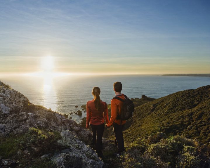 Paar beobachtet Sonnenuntergang auf einem Berg