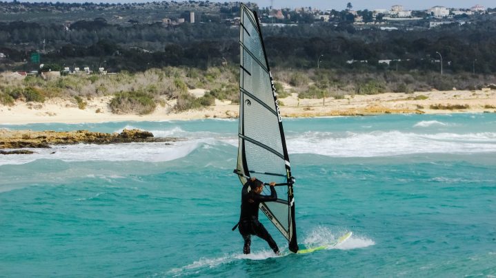 Mann windsurft auf offenem Meer an der Küste