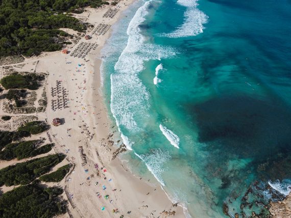 Türkisblauer Strand einer großen Bucht von oben auf Mallorca