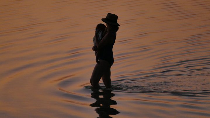 Yvonne mit Tochter Ida am Sandstrand bei Sonnenuntergang.