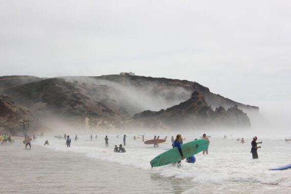 Surferstrand mit hohen Wellen und großen Klippen in Portugal an der Praia do Amado. 