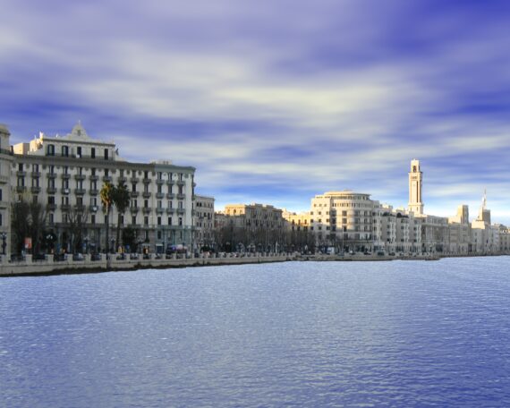 Der Hafen von Bari mit blauem Wasser und hellen Gebäuden von weiter weg