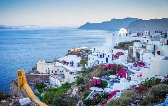 Die griechische Insel Santorin mit weißen Steinhäusern mit blauen Türen und rosafarbenen Bougainvilleas