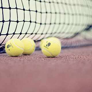 Drei Tennisbälle mit einem Tennisnetz