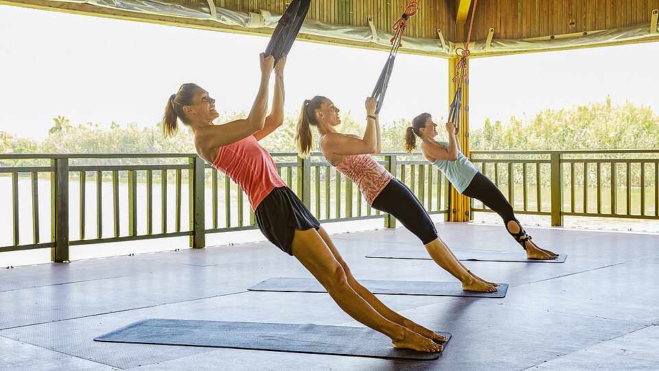 Gruppe von Sportlern beim Training mit Slings