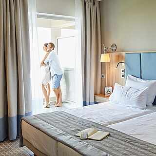 Gemütliches Hotelzimmer mit Blick auf ein sich umarmendes Paar
