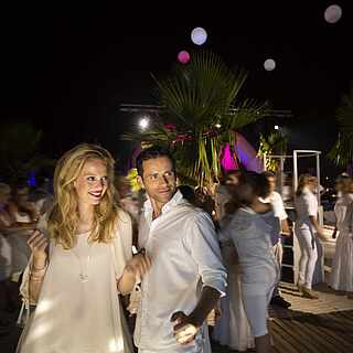 Mann und Frau im weißen Outfit auf der Tanzfläche