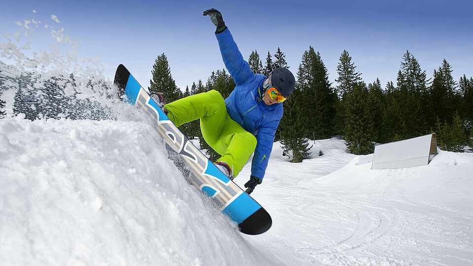 Ein Snowboarder der einen kleinen Abhang überwindet