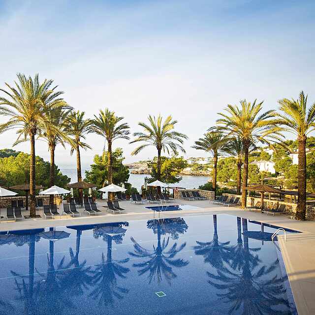 Poolanlage im ROBINSON Club Cala Serena Pool mit Liegen und Blick aufs Meer