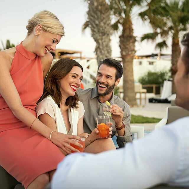 Zwei Paare unterhalten sich am Pool.