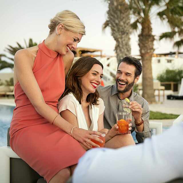 Zwei Paare unterhalten sich am Pool.