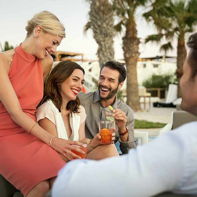 Zwei Paare unterhalten sich am Pool.