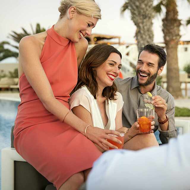 Gäste aus aller Welt Zwei Paare unterhalten sich am Pool.