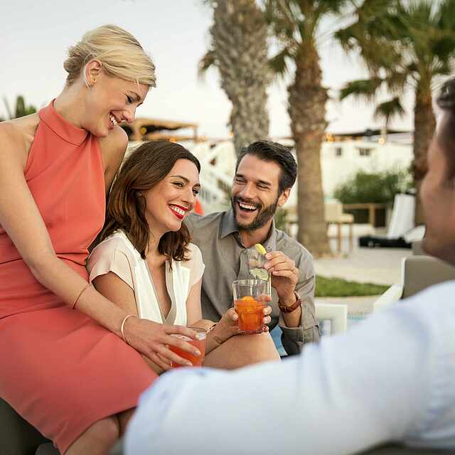 Zwei Paare unterhalten sich am Pool.