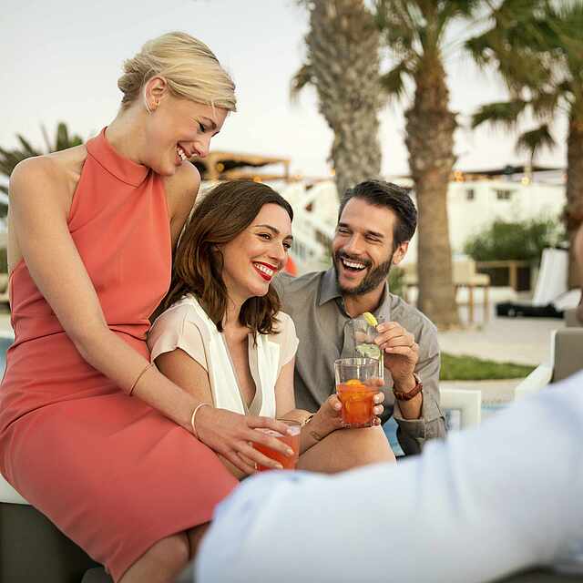 Zwei Paare unterhalten sich am Pool.