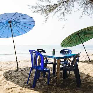 Ein Tisch am Sandstrand mit Ausblick auf das Meer