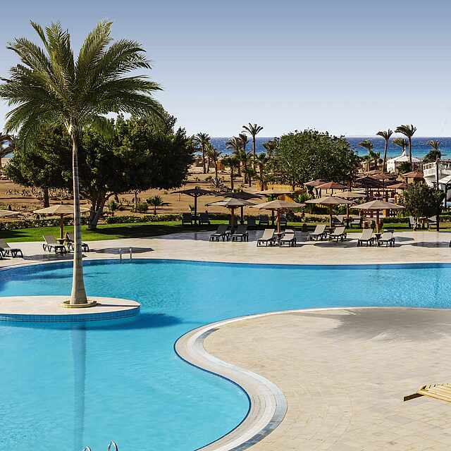 Pool mit Sonnenliegen und Meerblick