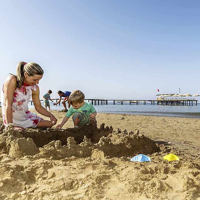 Mutter und Sohn am Strand, Meer, Sandburg, Steg