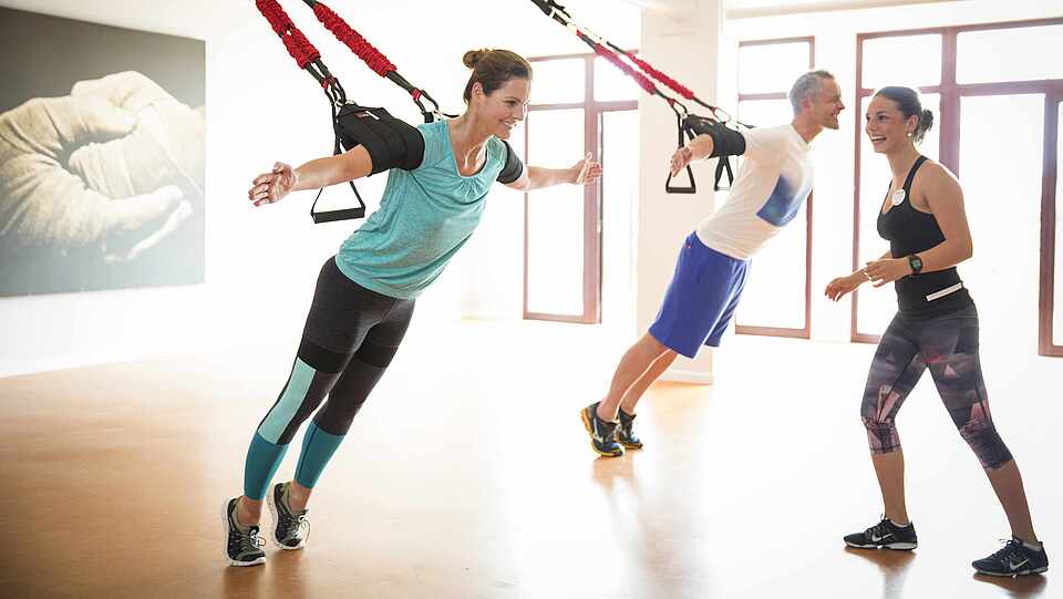 Sportler mit Personal-Trainer im Fitnessraum