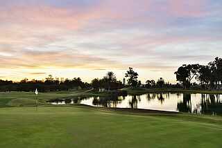Gartenanlage mit Teich während des Sonnenuntergangs